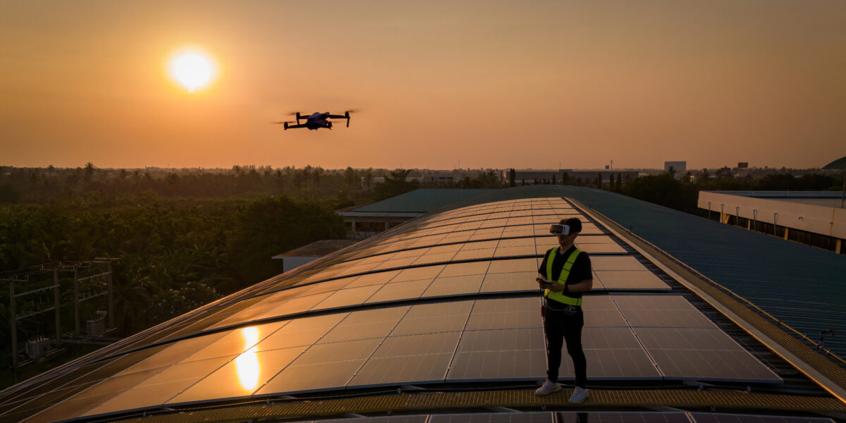 a man standing on a roof with a drone flying over